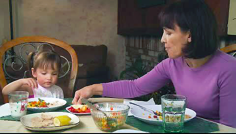 Grandmother fussing and arranging granddaughter's food