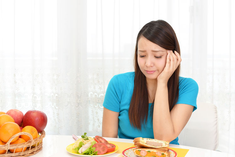 Young woman looking upset at mealtime