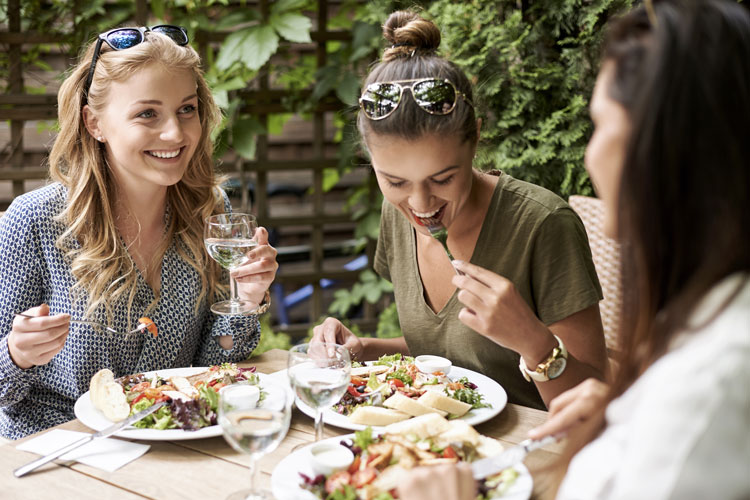 Smiling young women sharing meal Smiling young women sharing meal
