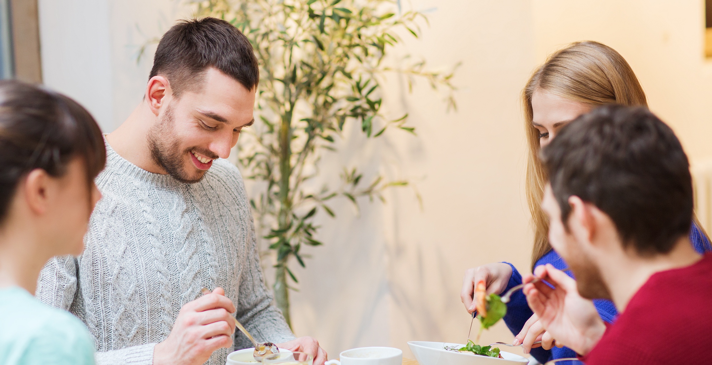 Two young couples enjoying a meal together