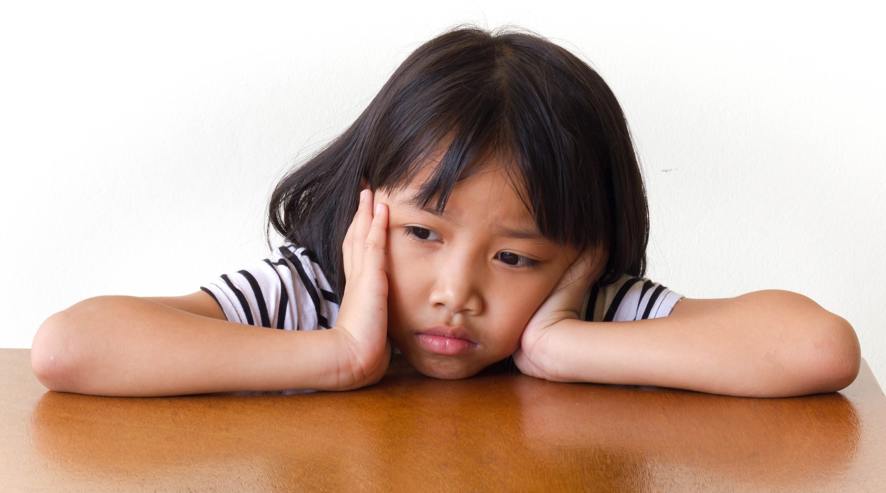 Dejected little girl at table 