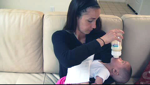 Bottle feeding baby's head back, neck at awkward angle